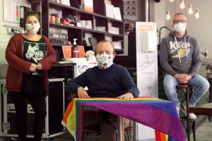 Drei Mitarbeiter*innen des anyway sitzen mit Maske und Abstand im Café.